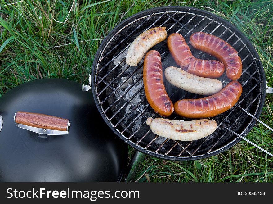 Fresh sliced grilled sausages, outdoor barbecue