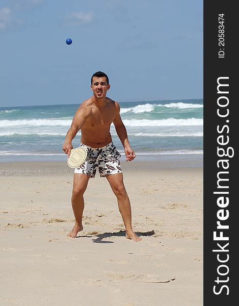 Attractive men playing beach tennis on the beach