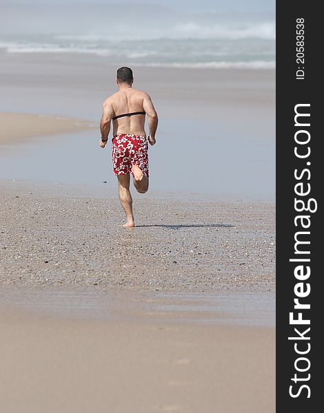 Middle age men running full of energy on the beach with a heart rate