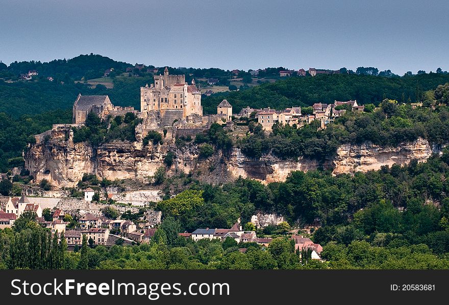 View over the valley to a French hillside town with Chateau