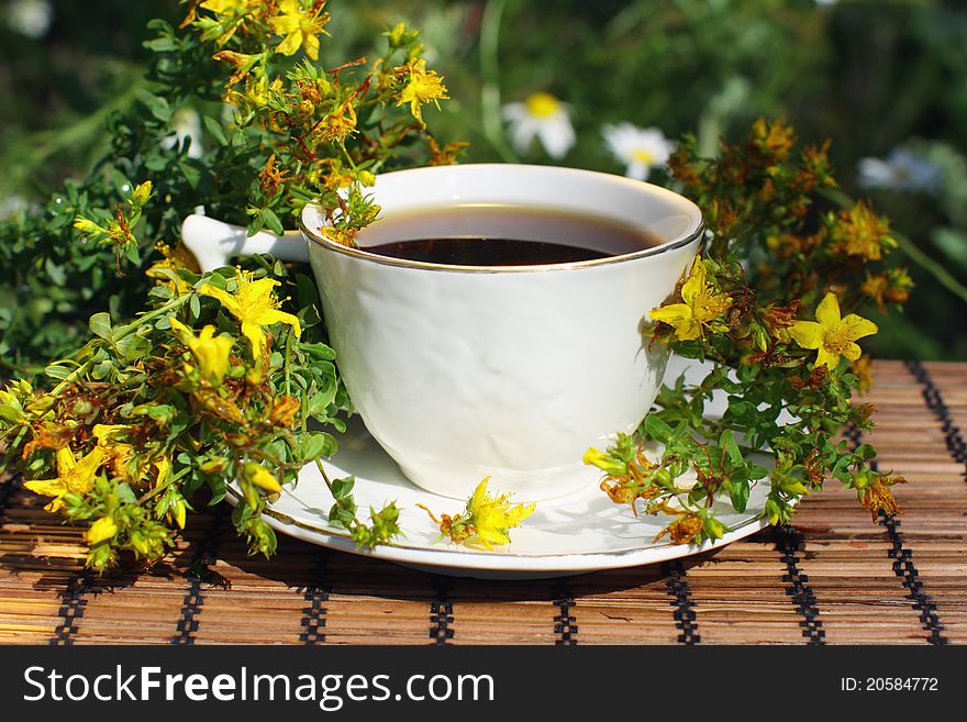 A cup of black tea with herb (Hypericum perforatum). A cup of black tea with herb (Hypericum perforatum).