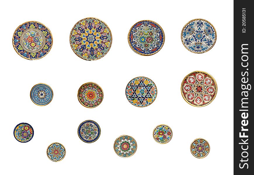 14 painted round wall-plates diferent sizes against a white background