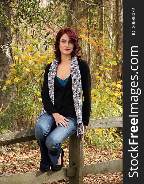 A Young Caucasian woman poses for portrait in an Autumn Setting. A Young Caucasian woman poses for portrait in an Autumn Setting.