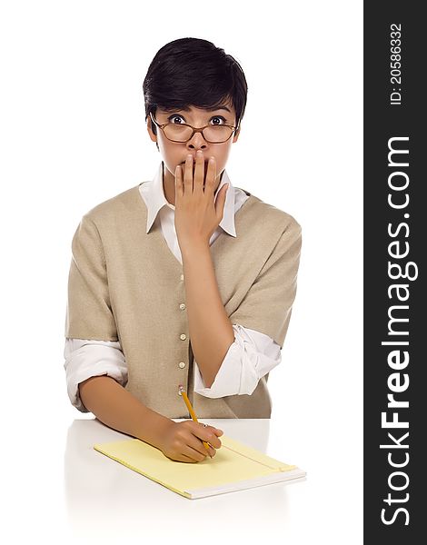 Shocked Mixed Race Young Adult Female Student at Table with Pad of Paper and Pencil Isolated on a White Background.