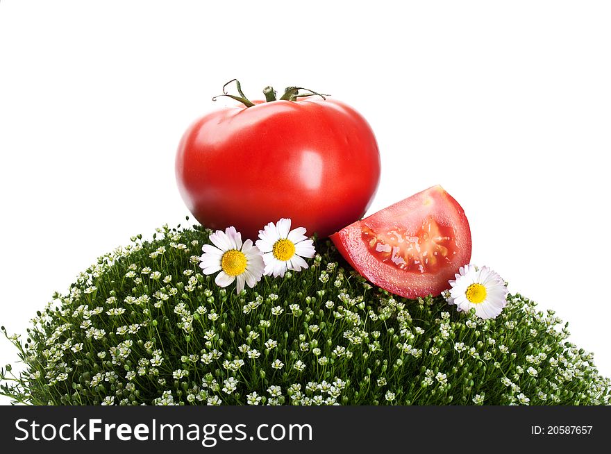 Fresh tomato on a green grass isolated on a white background