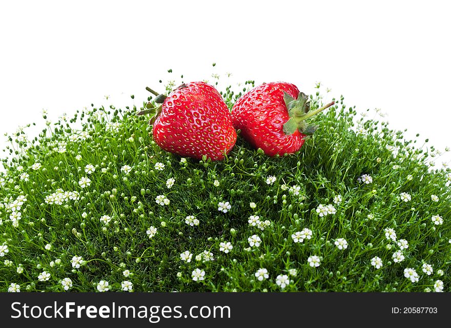Fresh strawberry on a green grass isolated on a white background