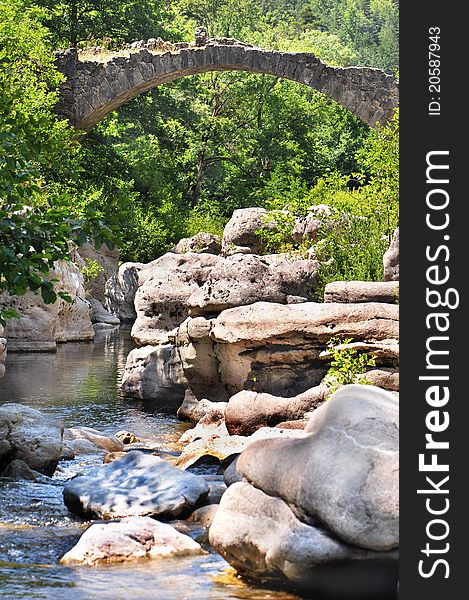 An ancient stone bridge crossing a river. An ancient stone bridge crossing a river