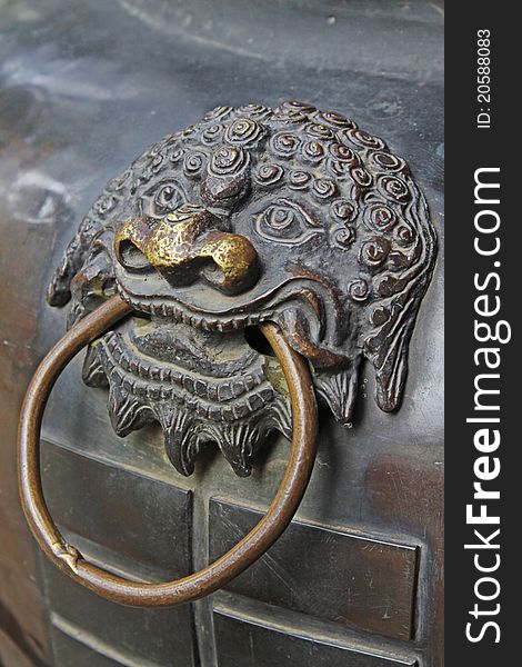 Lion head on a chinese copper censer surface. Lion head on a chinese copper censer surface