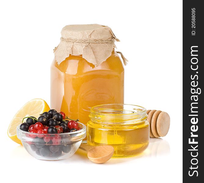 Glass jar full of honey, lemon and berry isolated on white background