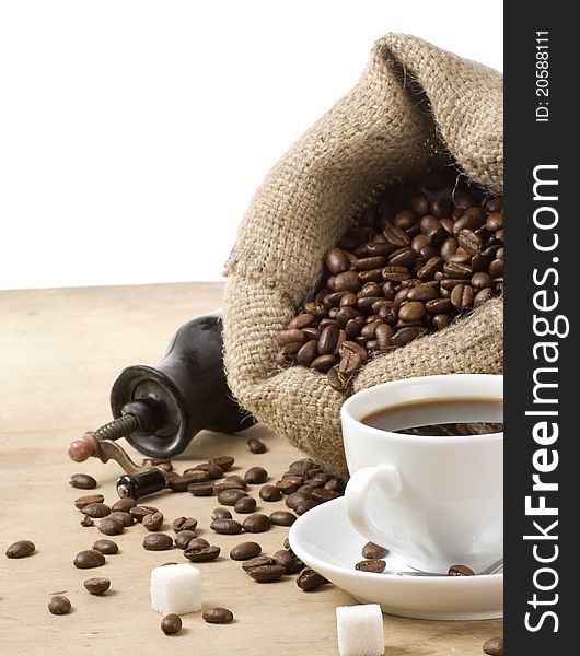 Cup of coffee and grinder with roasted beans isolated on white background