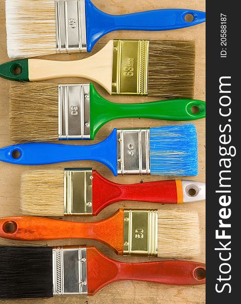 Colorful paintbrush on wooden background