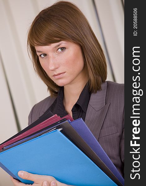 Portrait of young businesswoman with files