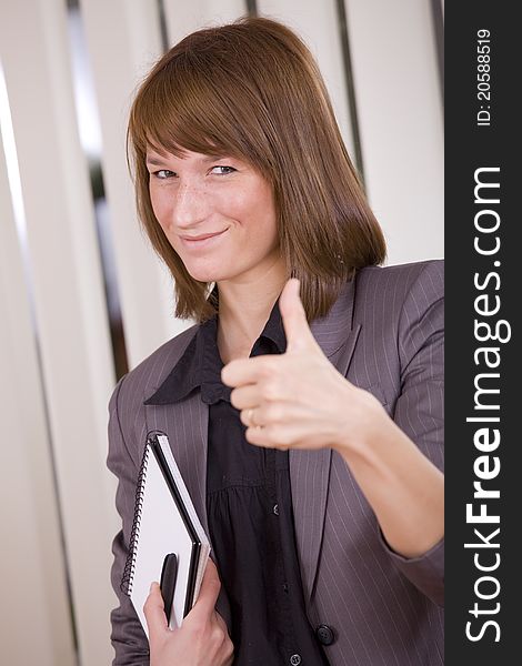 Happy businesswoman with thumb up in office