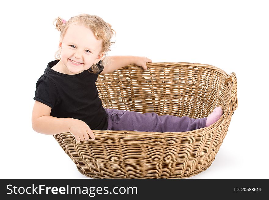 Beautiful little girl is sitting in basket and laughing. Beautiful little girl is sitting in basket and laughing