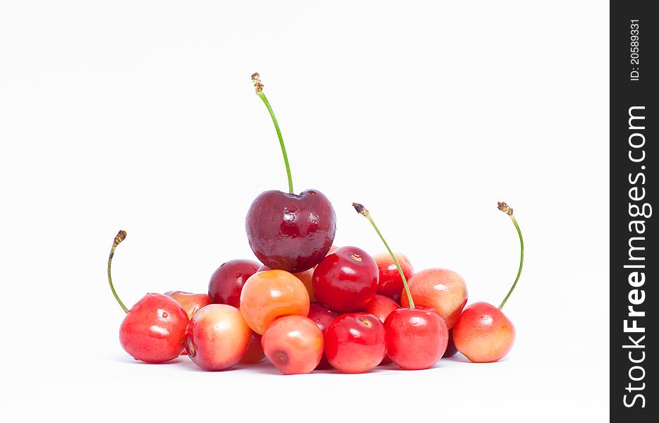 Pile of yellow and red cherries on white background