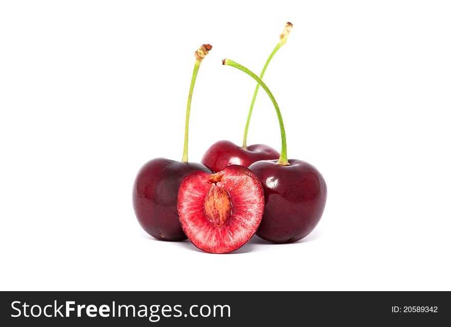 Three red cherries and a half with stems on white background. Three red cherries and a half with stems on white background