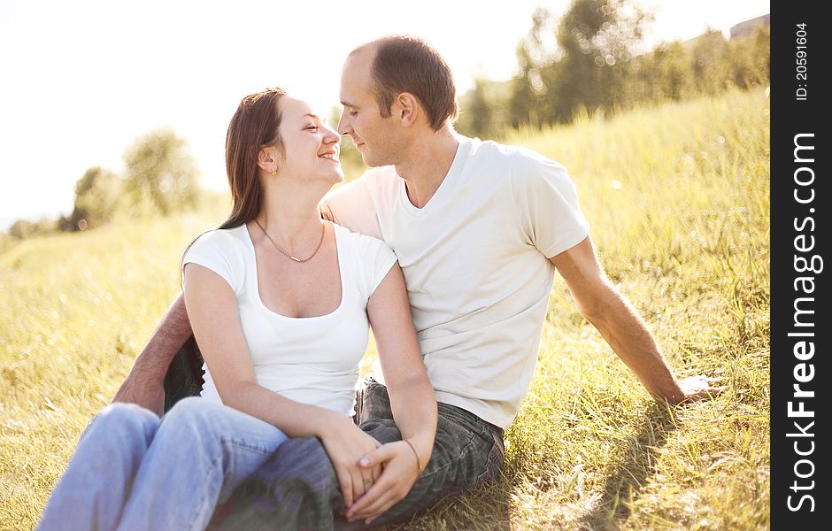 Happy young couple spending time outdoor on a summer day at sunset