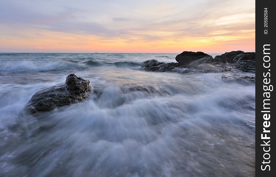 Sunrise over sea with rock coast