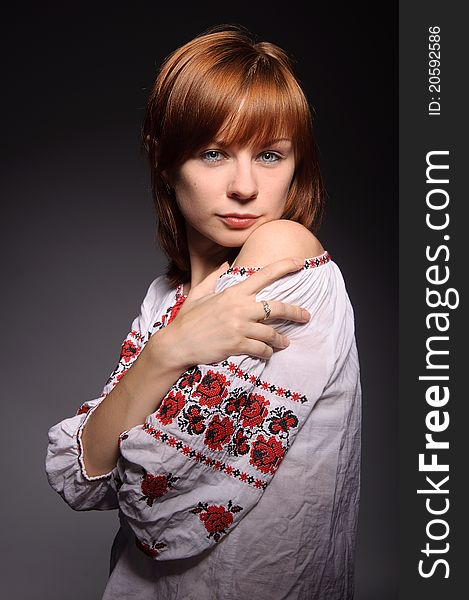 Beautiful red-haired girl with blue eyes wearing ukrainian national cross-stitched costume. Beautiful red-haired girl with blue eyes wearing ukrainian national cross-stitched costume