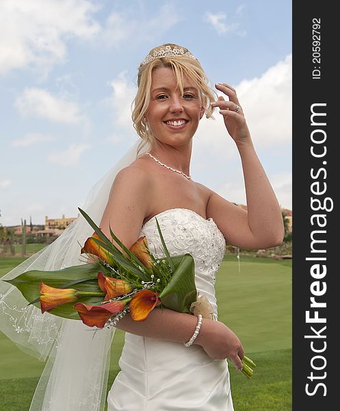 Bride in the sunshine at the reception at a golf course