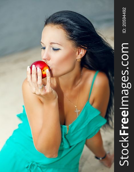 Common young woman eating a peach. Common young woman eating a peach