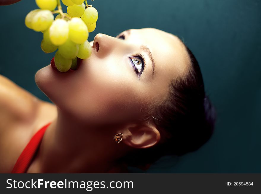 Beautiful young woman eating grapes. Beautiful young woman eating grapes