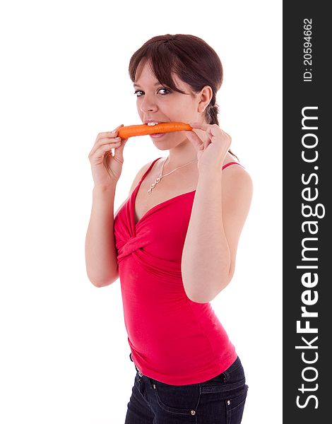The pretty young woman biting into a carrot. The pretty young woman biting into a carrot