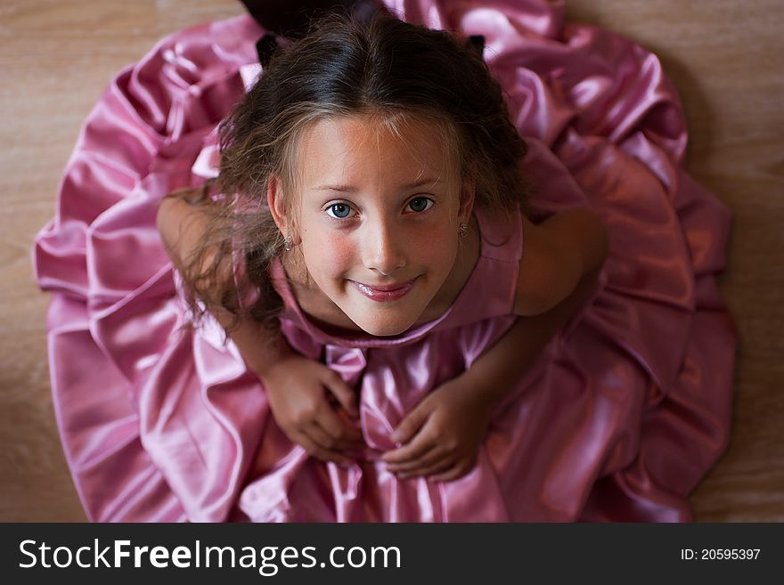 Smiling cute little girl in a pink dress festive