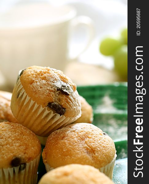 Muffin with chocolate on green plate and cup