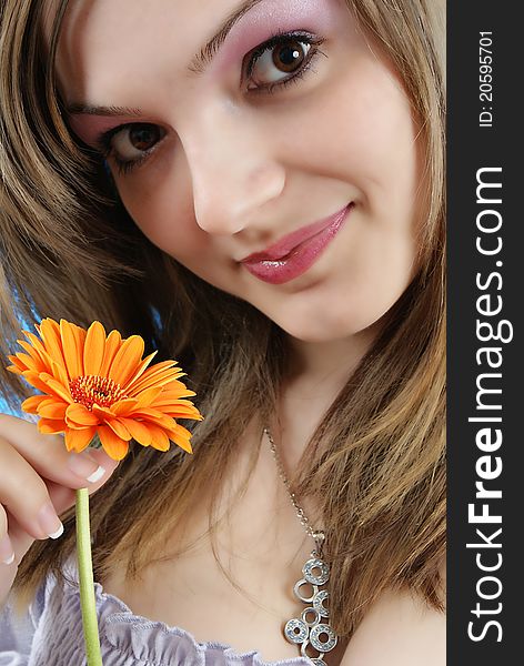 Attractive smiling woman portrait with flower in her hand