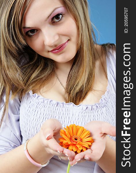 Attractive smiling woman portrait with flower in her hand