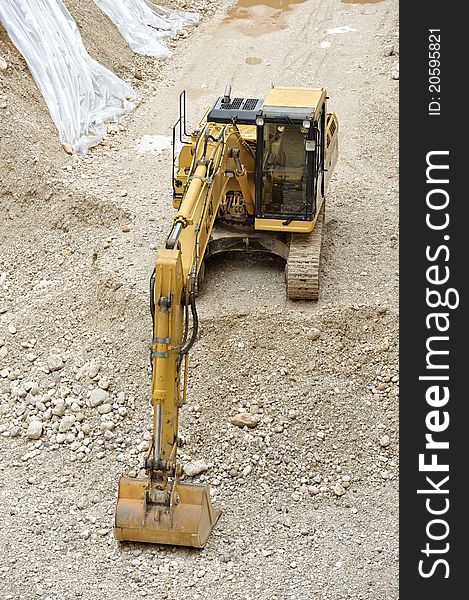 Yellow digger in the yard with shovel gravel and caterpillar. Yellow digger in the yard with shovel gravel and caterpillar