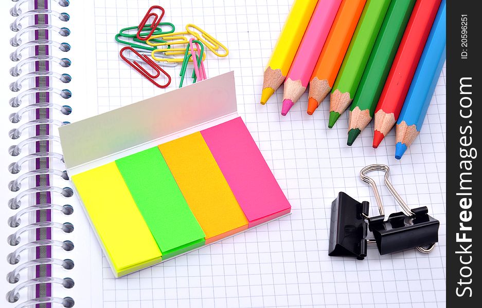 Colorful pencils and note papers on white