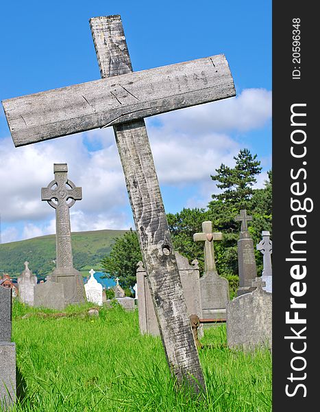 Pre 1900 stone statue of angel in gesture of humility on a cross against bright blue cloudless sky from a grave in the famous landmark Milltown Cemetery Belfast, which is the largest Catholic burial ground in Belfast and synonymous with Irish Republicanism. Pre 1900 stone statue of angel in gesture of humility on a cross against bright blue cloudless sky from a grave in the famous landmark Milltown Cemetery Belfast, which is the largest Catholic burial ground in Belfast and synonymous with Irish Republicanism.