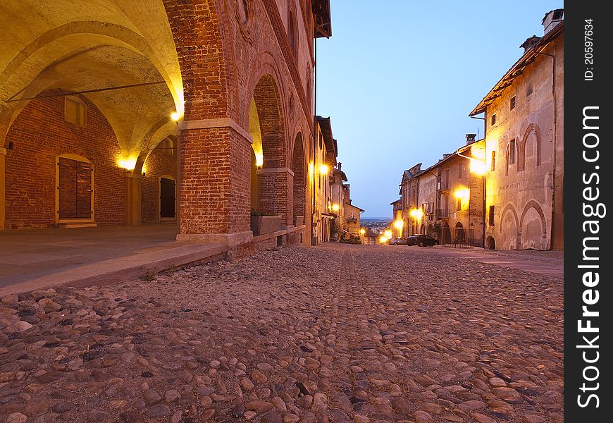 Night view of a typical street of the old town of Saluzzo