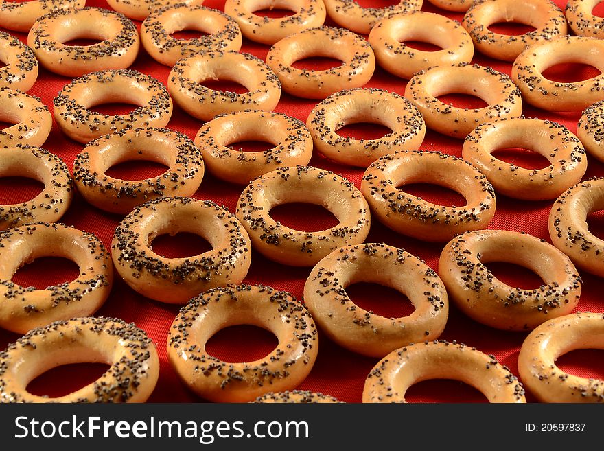 Tasty baked bread rings on the red background