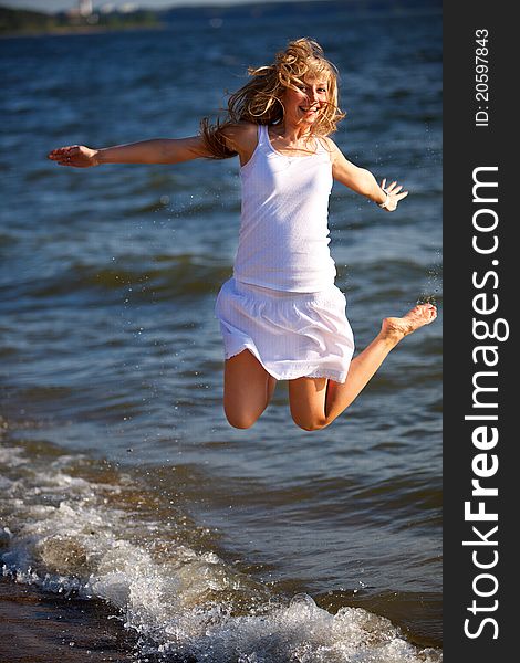 Happy Woman Jumping On The Sea Beach