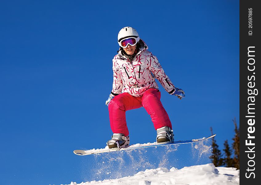 Snowboarder jumping through air with deep blue sky in background