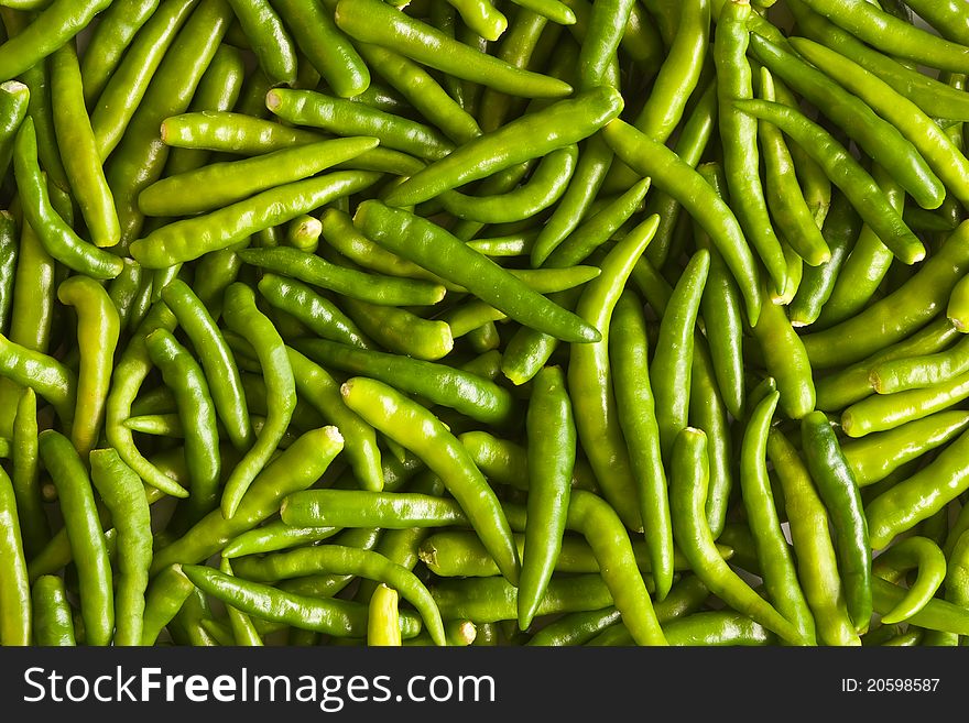 Many spicy green chillies background