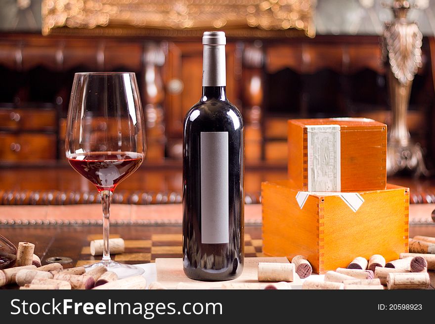 The still life with red wine, bottle, glass and old barrel