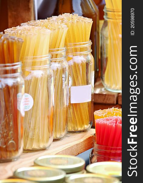 Golden honey sticks in glass jars.