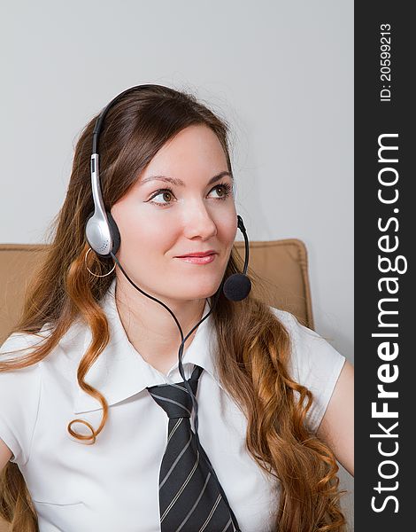 Girl - the operator in headphones in the office. Girl - the operator in headphones in the office