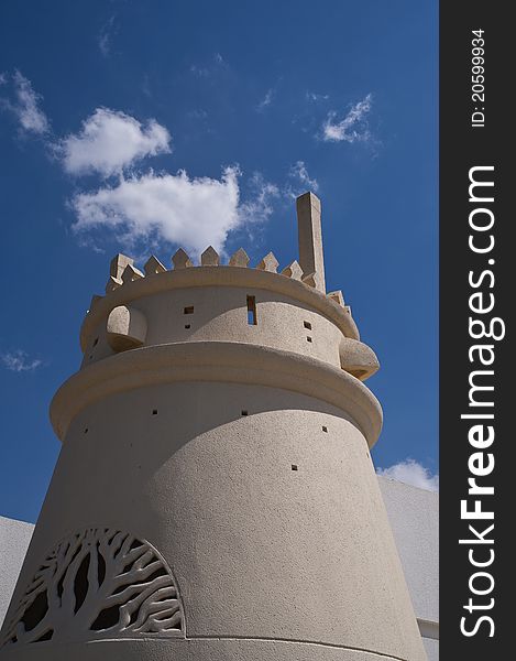 View of an Arabian Castle Turret under vivid bright blue cloudy sky in the UAE. View of an Arabian Castle Turret under vivid bright blue cloudy sky in the UAE