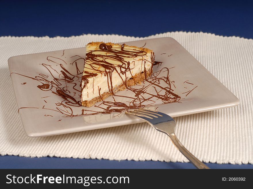 A piece of cheesecake with chocolate drizzled over it
