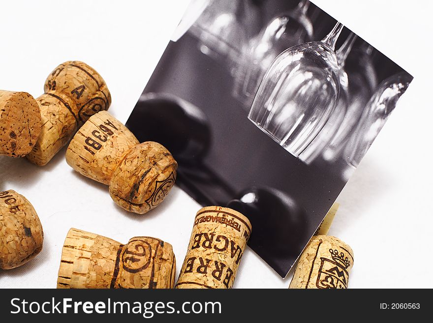 A black and white picture of wine glasses on display with corks. A black and white picture of wine glasses on display with corks