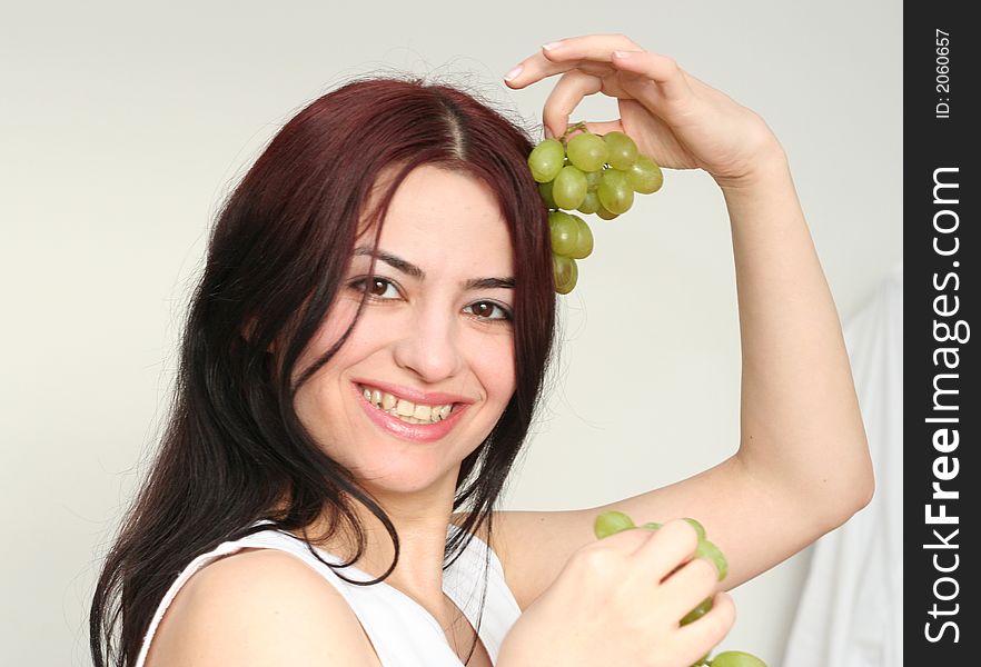 Oriental pretty girl give the grape in a hand. Oriental pretty girl give the grape in a hand