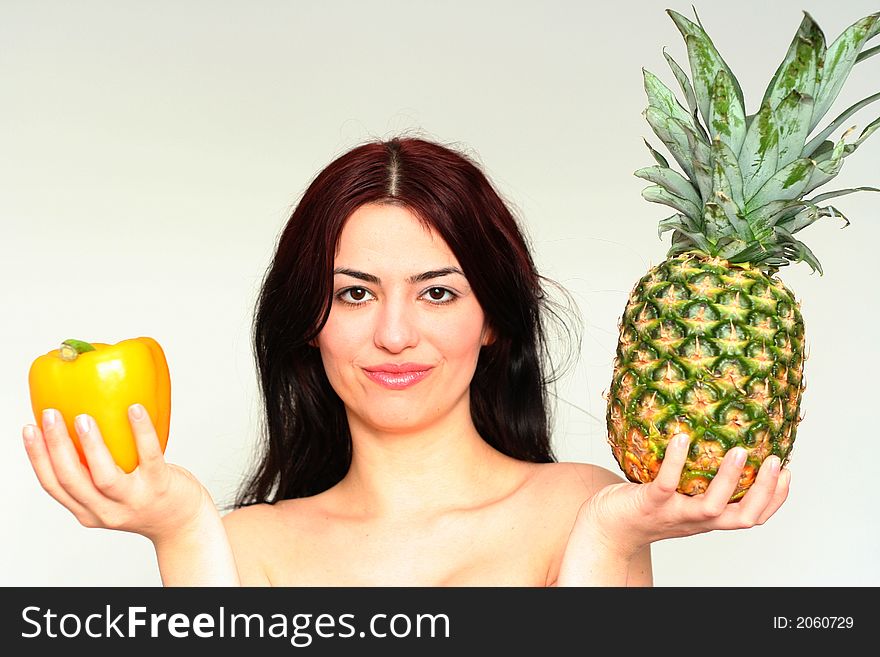 Asian pretty girl with yellow peper and pineapple in a hand. Asian pretty girl with yellow peper and pineapple in a hand