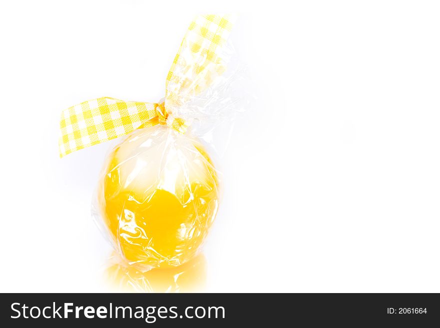 Pretty easter candle reflected on white background