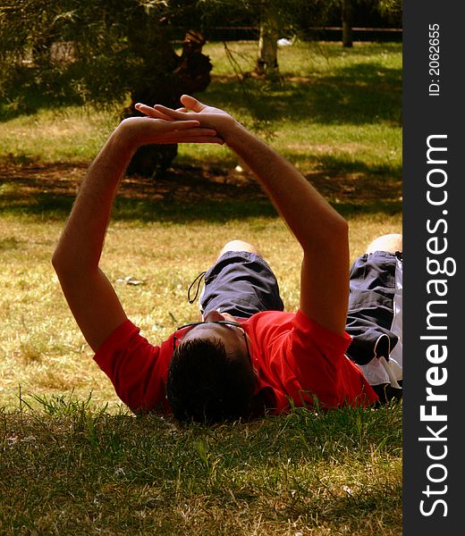 Man relaxing on back in park in the shadow