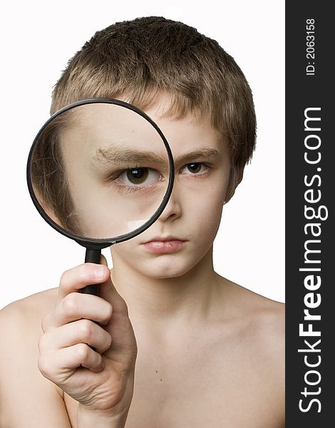 Boy looking through the lens on neutral background